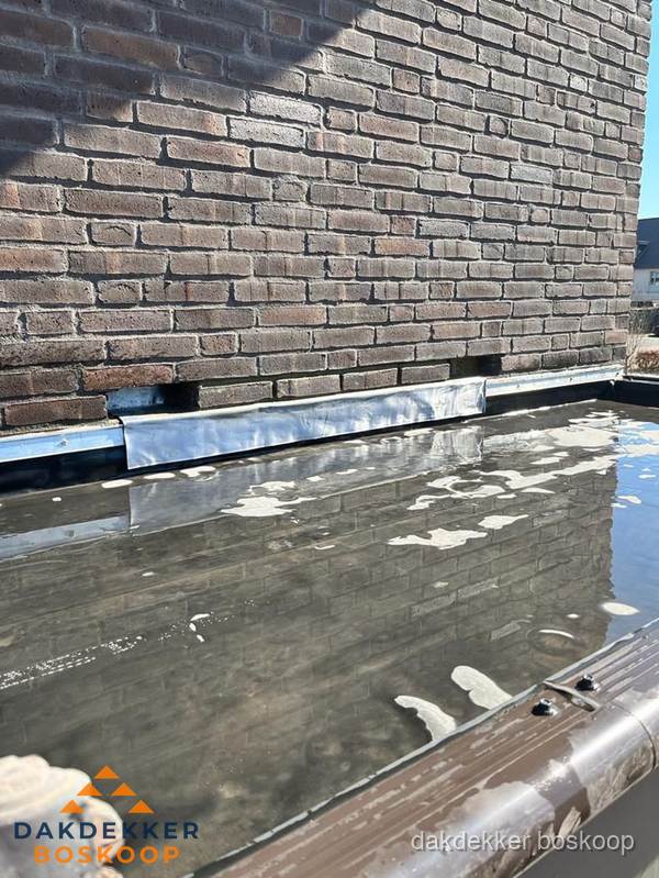Stilstaand water op plat dak door slechte afwatering in Boskoop Stilstaand water op plat dak door slechte afwatering in Boskoop